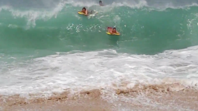 Tourists get smashed at Waimea Bay.