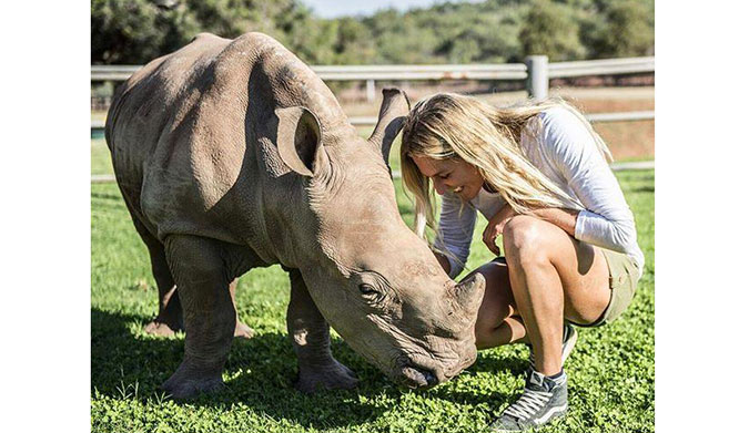 Stephanie Gilmore with a baby rhino whose mother was killed by assholes so other assholes can buy horns.