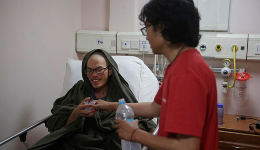 A family member gives water to Liang Sheng-yueh at the Grande Hospital in Kathmandu, Nepal, on Wed., April 26, 2017, after his rescue. Photo: AP