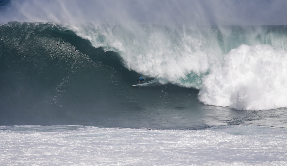 Grant \"Twiggy\" Baker pulls into a massive Pe\'ahi tube. Photo: WSL/Morris