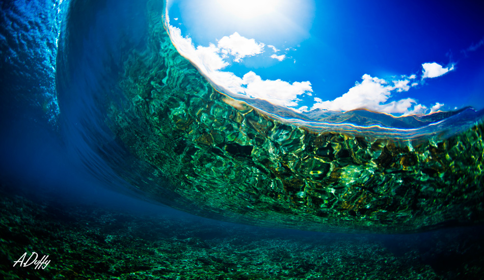 Underneath Teahupoo. I love how you can see the reflection of the reef and the mountains in the background. Photo: <a href=\"http://adamduffyphotography.com/\">Adam Duffy.</a>