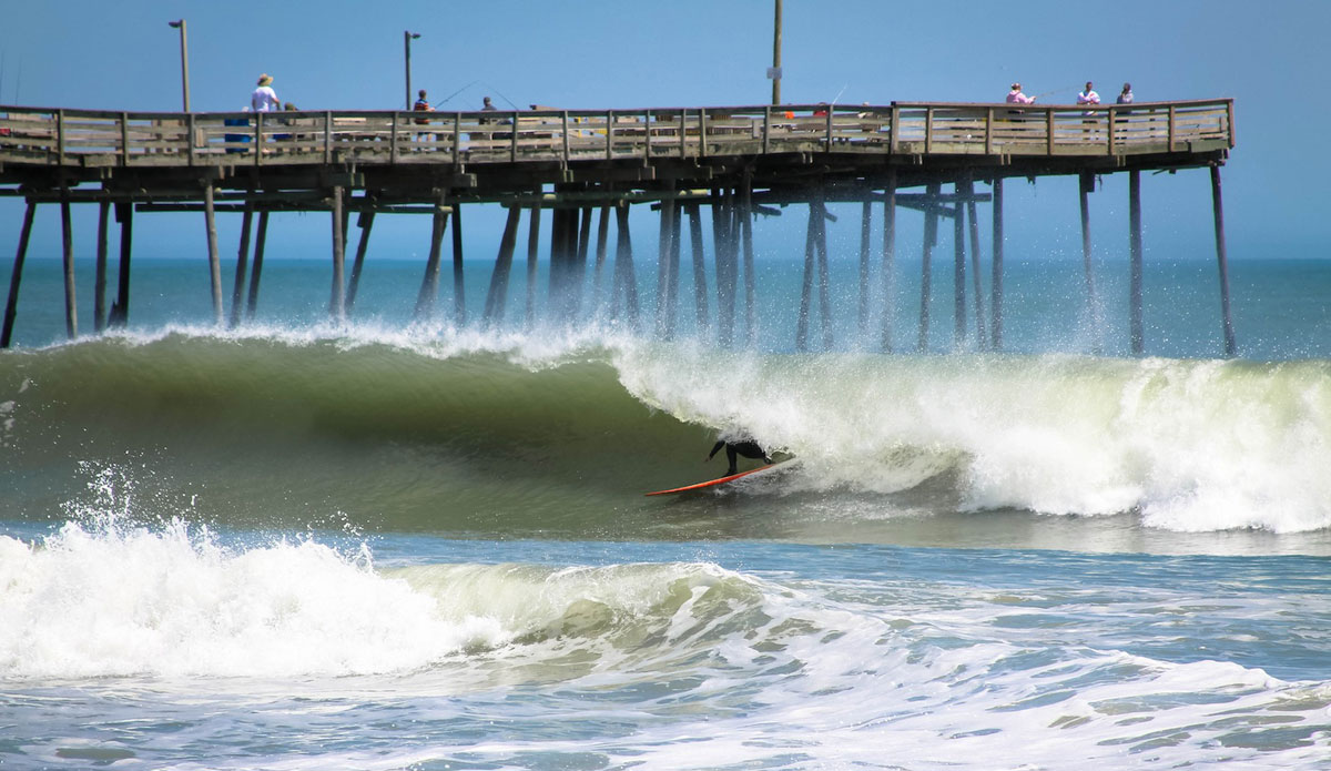 An unidentified longboarder charges hard on a hollow runner. Photo: John Streit