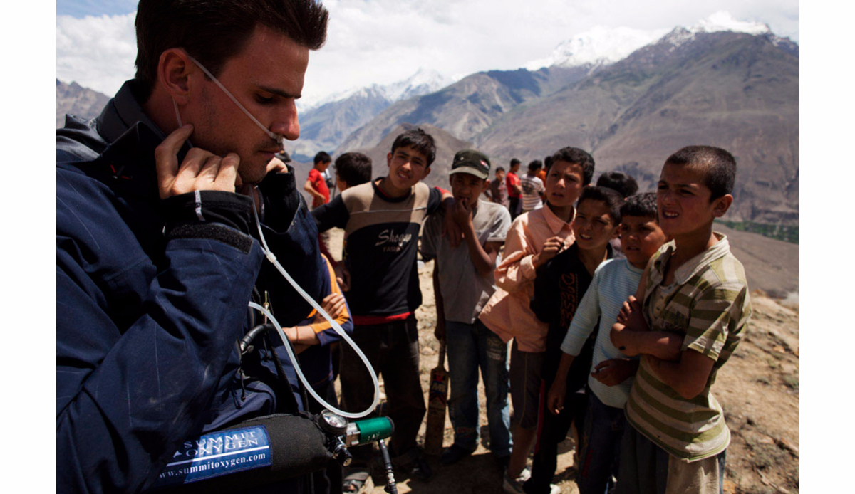 Spanish pilot Horacio Llorens connects his oxygen bottle as young curious children look on in Hunza, northern Pakistan. Photo: <a href=\"https://instagram.com/krystlejwright/\">Krystle Wright</a>