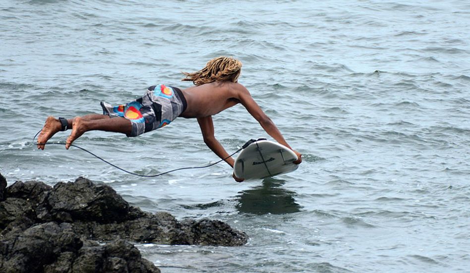 Gilbert Brown of Costa Rica jumps off the rocks to avoid the monster paddle out. Photo: <a href=\"http://www.isawsg.com/\" target=_blank>ISA/Michael Tweddle</a>.