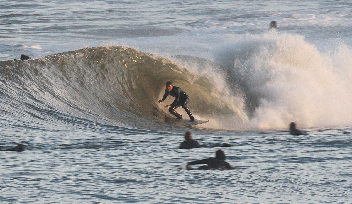 This shot is from Christmas—still no gloves or hoods. A normal winter would have seen us in full winter gear by then. Unknown surfer catching an evening session at Avalon pier with the neighborhood crew. Photo: Mickey McCarthy