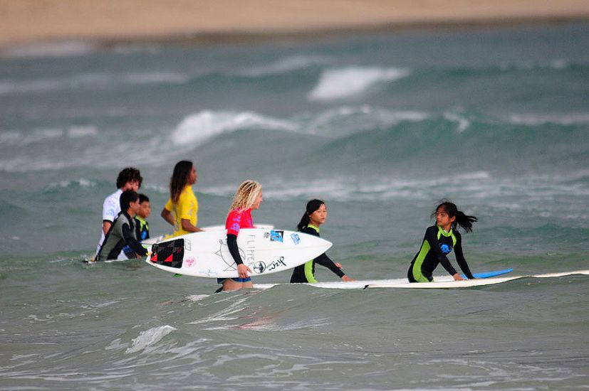 Wanning youth go for a surf with a couple of competitors. Photo: ISA/Tweddle