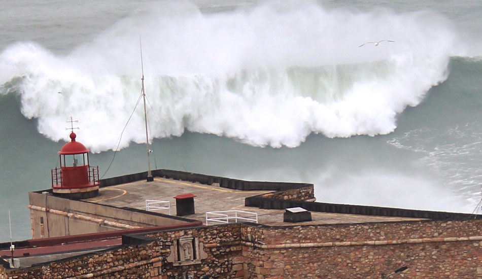 If the lighthouse isn\'t enough warning to stay off the rocks, the gigantic waves should be. Photo: Jose Pinto