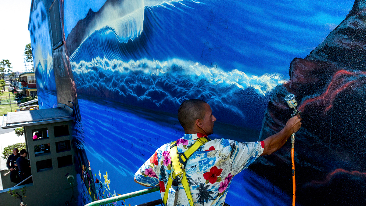 Here\'s myself painting the mural #11 of 101 Perfect Waves, my international mural project. This mural was painted in Downtown Los Angeles at Ann Street Elementary School and I had the help of over 300 students who painted fishes on the bottom part as well people from their community alongside LAPD officers. It was a really cool experience.