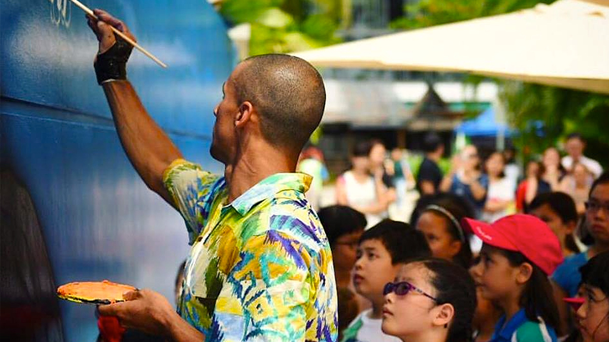 Here\'s myself teaching 50 kids how to paint a little fish on the wall. It was in November, 2015, at Sentosa Island, in Singapore, as part of the 101 Perfect Waves - International Mural Project. I painted three murals there and this one I had a collaboration of 50 chosen kids from different local schools. 