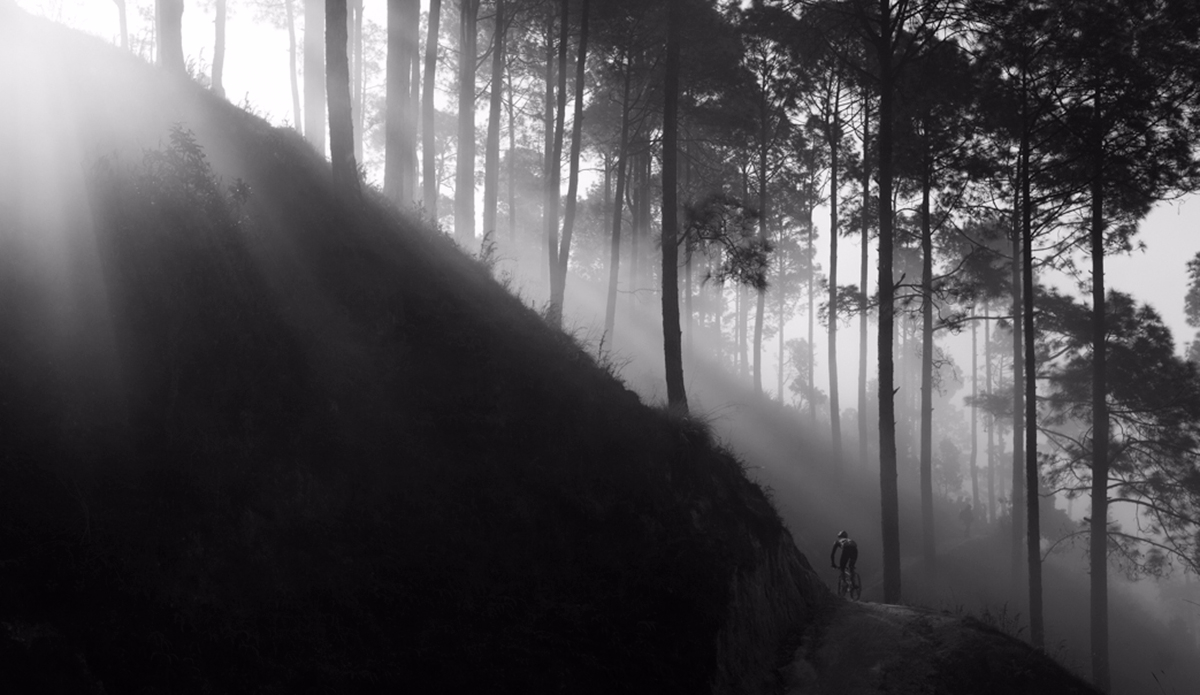 Early morning fog rolls through the hills on the outskirts of Kathmandu as a local mountain biker rides The Helipad trail in Nepal. Photo: <a href=\"https://instagram.com/krystlejwright/\">Krystle Wright</a>