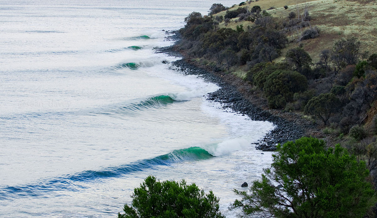 This is one of the very rarely surfed point breaks around the Hobart area of Tasmania. Although these waves get really good, they only happen just a couple of times a year, because they require a massive storm swell pretty much directly from the Antarctic region.  As you can imagine, it’s usually freezing cold because those same south winds from Antarctica are what brings the swell. I happened to walk out to this point with a crew of pros in 2006, including the Long Bros, Mark Healey, and Jamie Sterling. We just happened to stumble upon what was called the point\'s best swell in over 10 years. I shot this image on the first afternoon as the swell filled in. There was no one out, so we could not properly gauge the size of the swell.  We all walked away from it, thinking it was too small. This location is notorious for doing this. As it turned out, this place was absolutely pumping the next day with a good 40 or more surfers out. After having seen it with all the surfers out, I knew that this had actually been pretty good at about 4 or more feet in size when I pressed the shutter on this one. Photo: Sean Davey