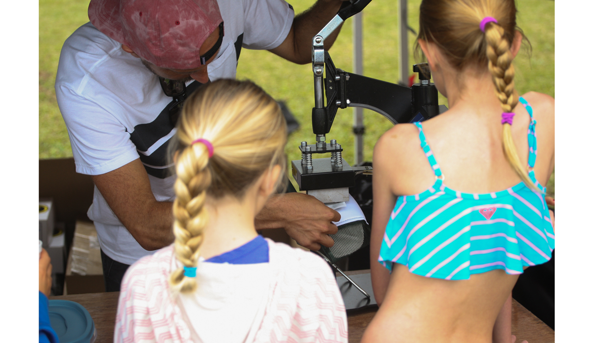 Micah Byrne from billabong puts together custom hats for the kids. Photo: <a href=\"http://www.danegrady.com/\">Dane Grady</a>