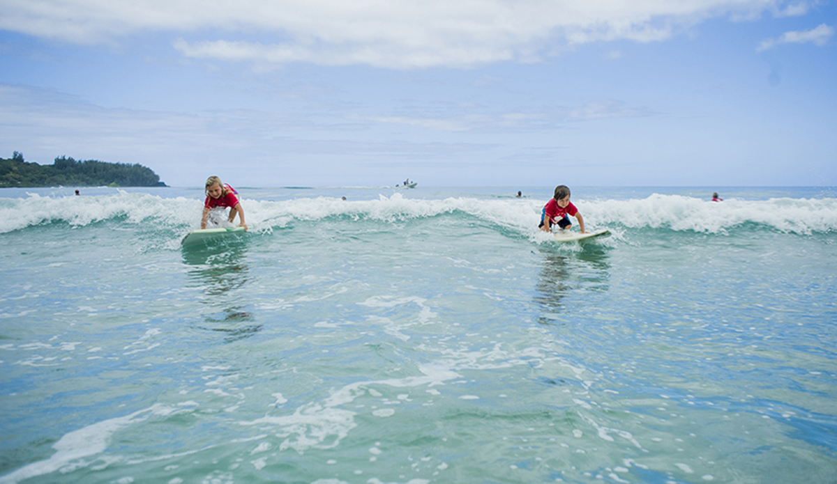 Bruce\'s kids Mila and Koby sharing a wave during the keiki push-in heat.