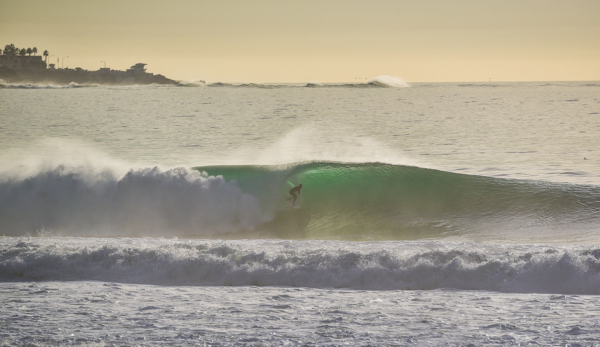 Derek Bockelman hand stalling in front of two fearless water photographers, Dave Hart and Mark Johnson.  This photo is special because it shows the amount of swell on the horizon. Photo: Michael Bonwell