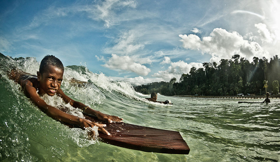 This was a little mission I did with Mikala and Dede to chase a swell. But durning a quick break from surfing I swam out and shot with the local kids while they were riding these planks of wood. This shot ended up being the cover on Transworld Surf travel issue. I\'m looking forward to this year when I go back there and show this grom his photo on the cover. Photo: Brad Masters