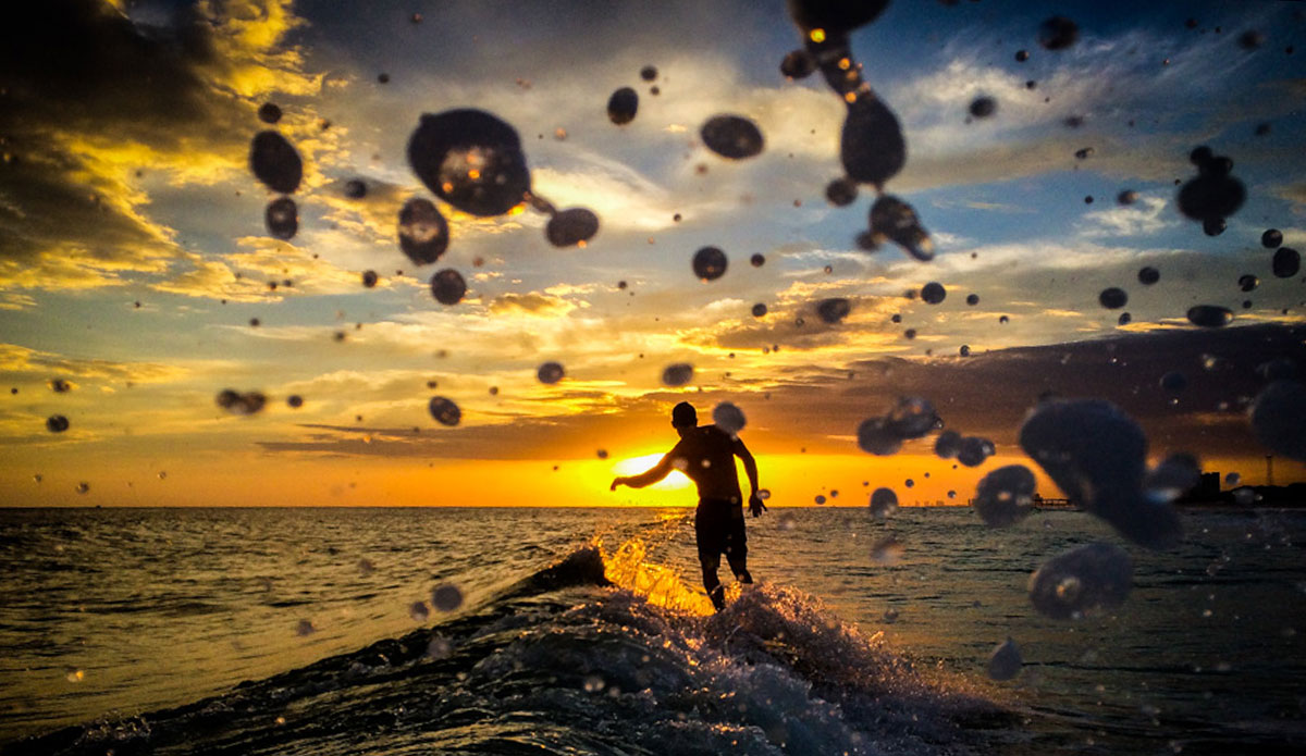 Scott Rumley rides off into a breathtaking sunset, leaving seemingly weightless water droplets in his wake. Photo: <a href=\"https://richbrooksphotography.squarespace.com/\"> Rich Brooks</a>