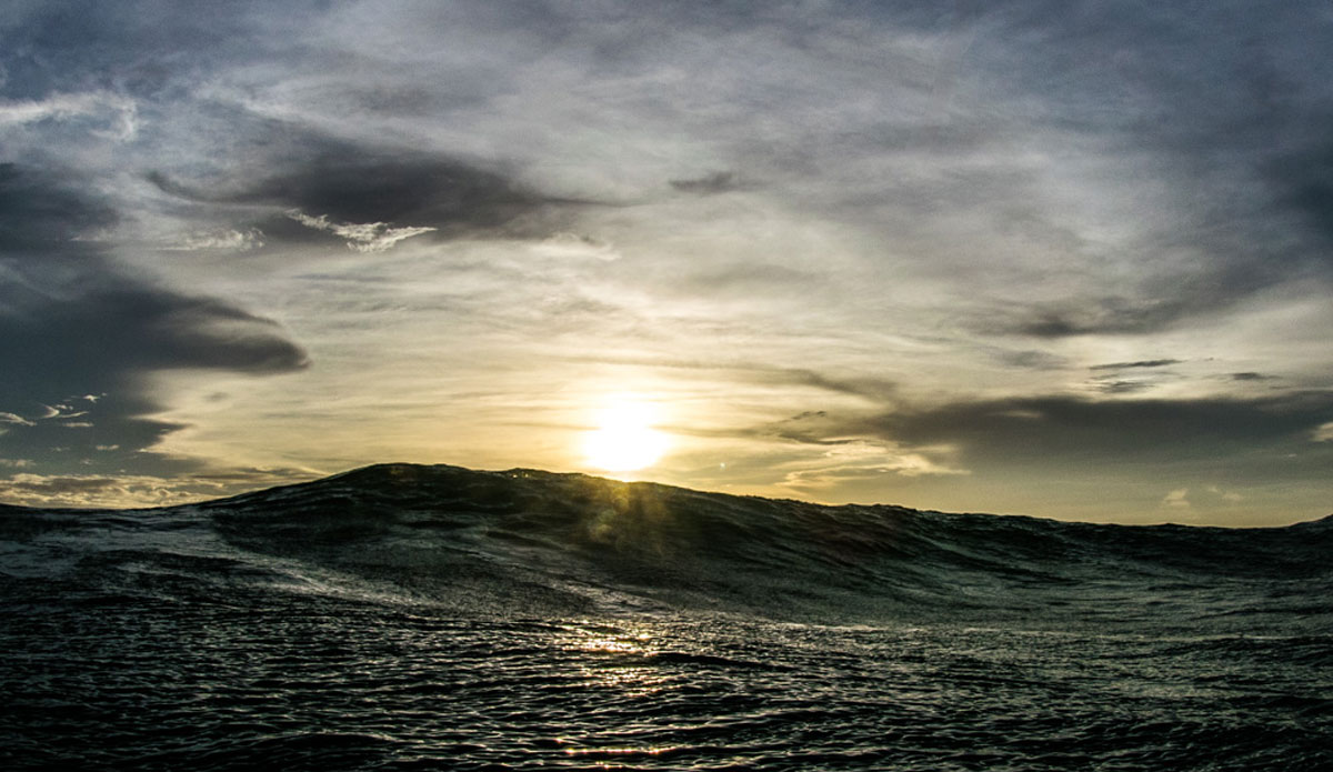 A peaceful setting sun drops behind a tumultuous mound of water. Sometimes the different aspects of nature aren\'t on the same page... Photo: <a href=\"https://richbrooksphotography.squarespace.com/\"> Rich Brooks</a>