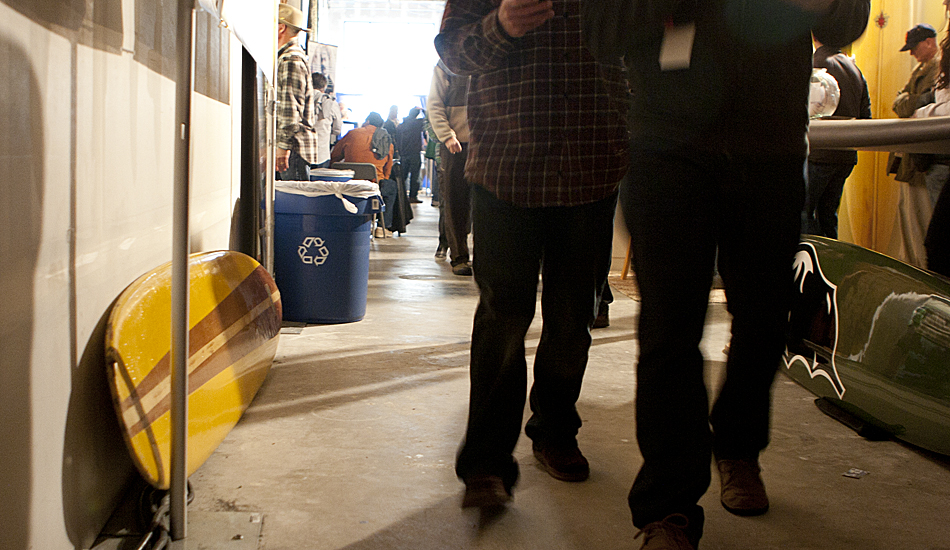 What looks to be a vintage Velzy longboard is passed by, unnoticed, by the crowd. We’re not sure why it was resting on the ground against the wall. Photo: Maggie Yount