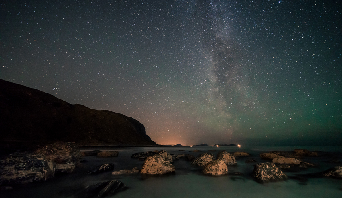 Where do we go?
Someone threw bulky rocks over the side of the bay, like dots against the petrol blue backdrop. Dead kelp on the beach, harvested in the storm. The Milky Way gives directions, throwing its white map over the sky.
Can’t go home yet. A purpose without objective.
Move on. Photo: Photo: <a href=\"http://www.fjordlapsephotography.com/\">Fjordlapse Photography</a>