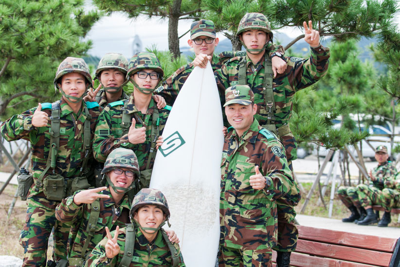 Some young ROK soldiers break the hardship and monotony of their compulsory two year military service defending Korea and grab a chance to pose with my surfboard during a military exercise and a pumping NE swell. I wonder if any of these guys know what a thruster is? Photo: <a href=\"http://www.shannonaston.com/\" target=_blank>Shannon Aston</a>.