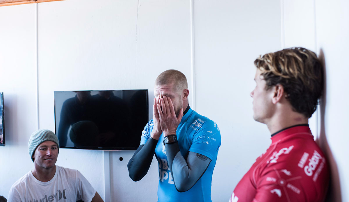 Mick Fanning of Australia (pictured blue) holds his head in his hands in disbelief after being attacked by a shark during the Final of the JBay Open while fellow finalist Julian Wilson (red) looks on, on Sunday July 19, 2015. Photo: <a href=\"http://www.worldsurfleague.com/\">WSL</a>/<a href=\"http://www.instagram.com/kirstinscholtz\">Kirstin Scholtz</a>