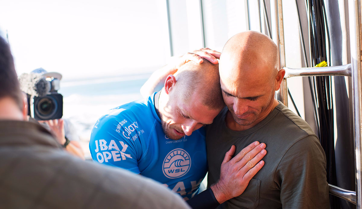 Mick Fanning of Australia (pictured blue) is consoled by 11X ASP World Champion Kelly Slater after being attacked by a shark during the Final of the JBay Open on Sunday July 19, 2015. Photo: <a href=\"http://www.worldsurfleague.com/\">WSL</a>/<a href=\"http://www.instagram.com/kirstinscholtz\">Kirstin Scholtz</a>