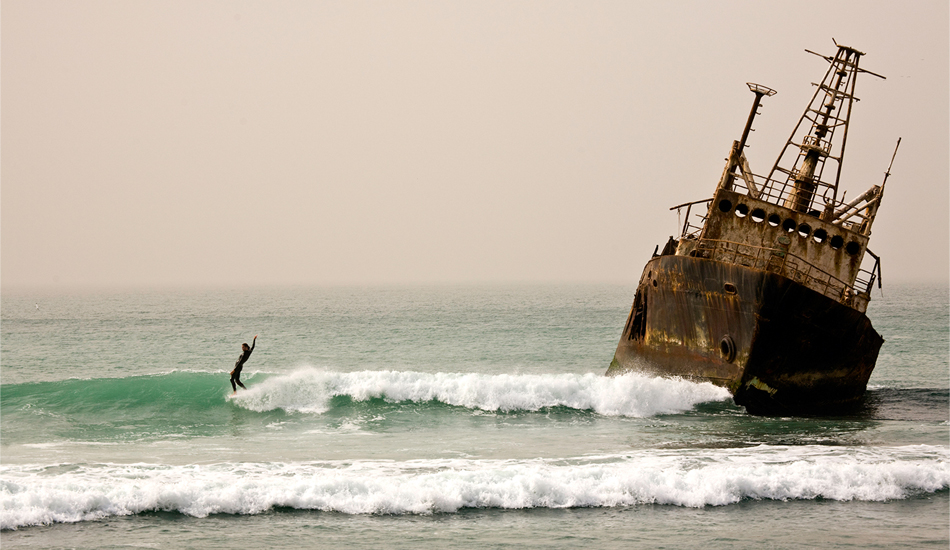 Meteorites: On Mauritania sits a wave that, in itself, isn\'t all that scary. What is scary, however, is the eerie wreck hung up on the reef. Pirate ghosts, anyone? Photo: John Seaton Callahan. 