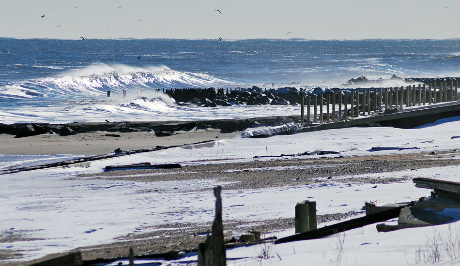 The sunny peak in the distance brings a bit of warmth to this frozen, snow-covered beach. Photo: Tim Leopold