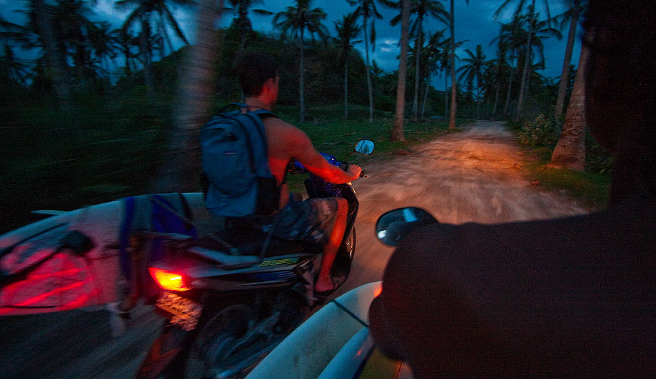 Getting around Indonesia\'s roads with a surf board usually means using a motorbike. Whoever came up with the idea of welding a makeshift rack to the frame of a Honda Vario probably should have put a patent on it, but by now it\'s definitely far, far, too late. Photo: <a href= \"http://tommyschultz.com/blog/category/photo-galleries/surf-photography-2/\">Tommy Schultz</a>