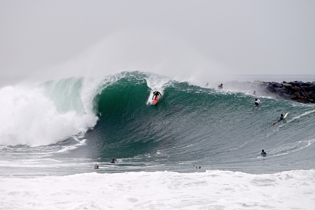 Yuri Goncalves drops into a large set wave at the Wedge. Photo: Benjamin Ginsberg / Driftwood Photography Studios