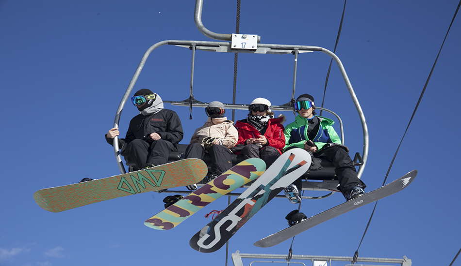 Snowboarders find motivation while taking in moments of the men’s slopestyle final from the ski lifts. 