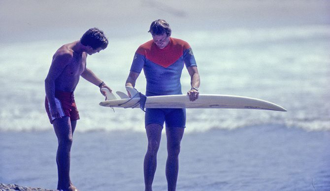 Simon Anderson holds a surfboard with a thruster setup