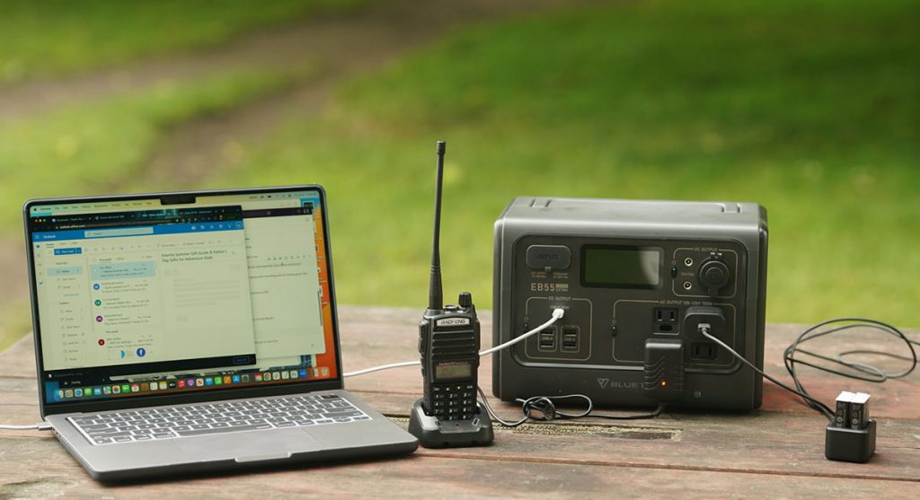 The Bluetti EB55 charging a laptop, two-way radio, and some gopro batteries.