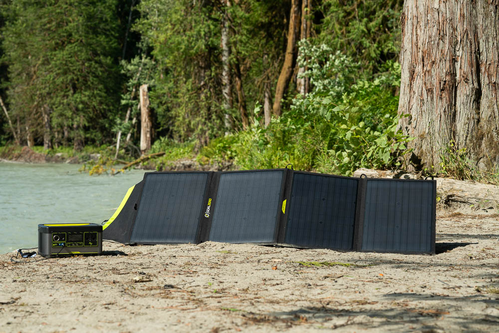 The GoalZero Yeti 500x and Nomad 100 solar panel next to a river in the wilderness.