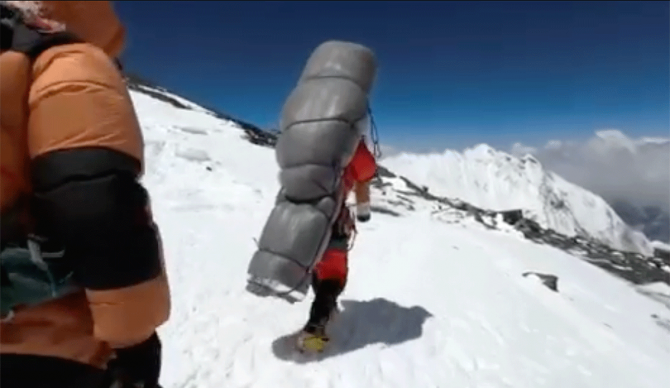 Gelje Sherpa carries a climber down Mt. Everest