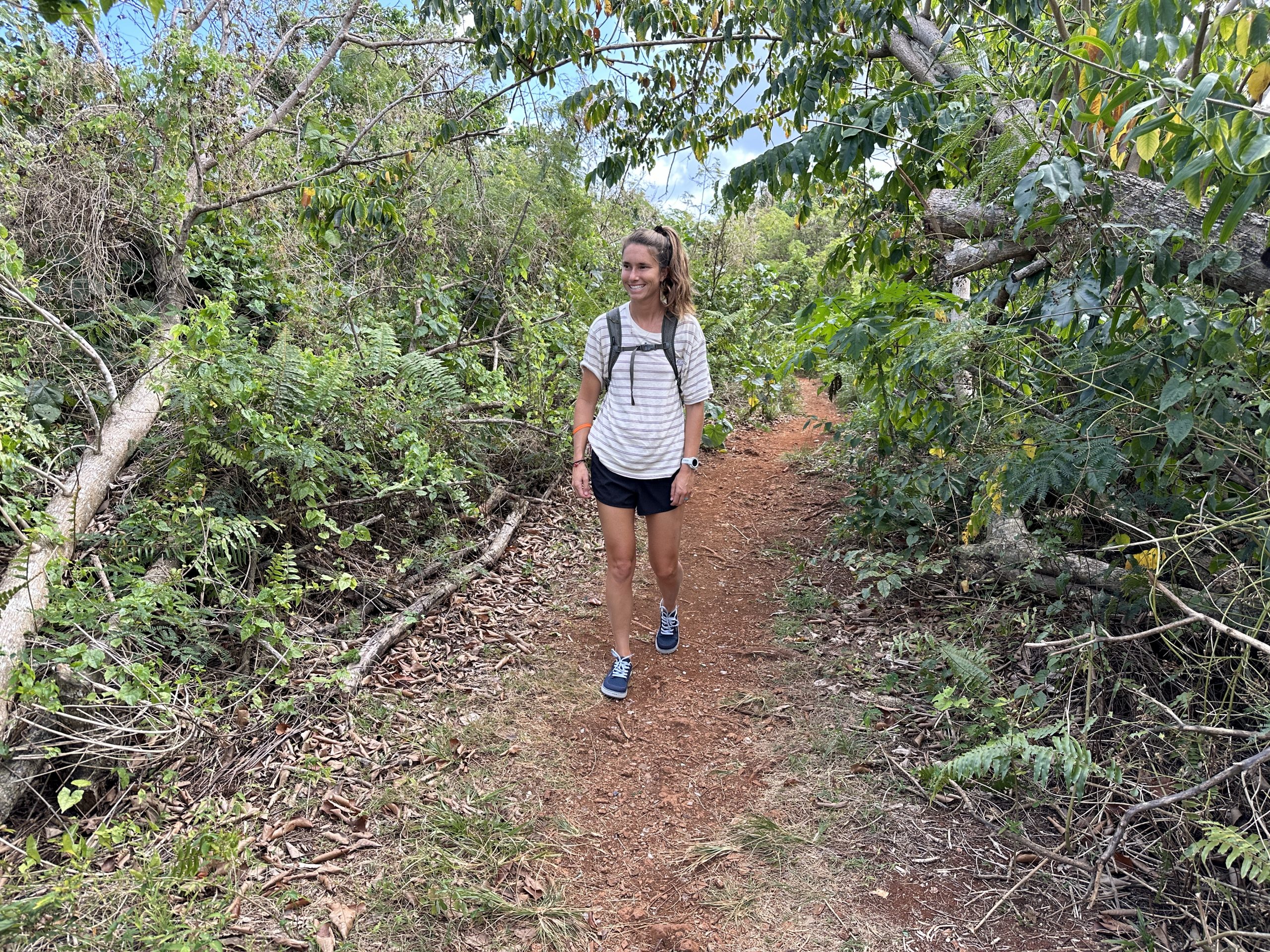 a woman walks down a trail while wearing astral brewess 2.0 water shoes