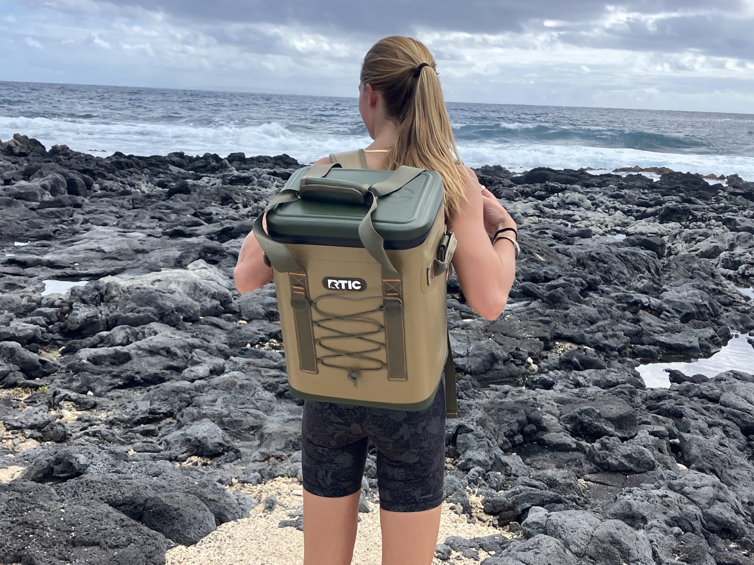 girl wearing an RTIC backpack cooler at the beach