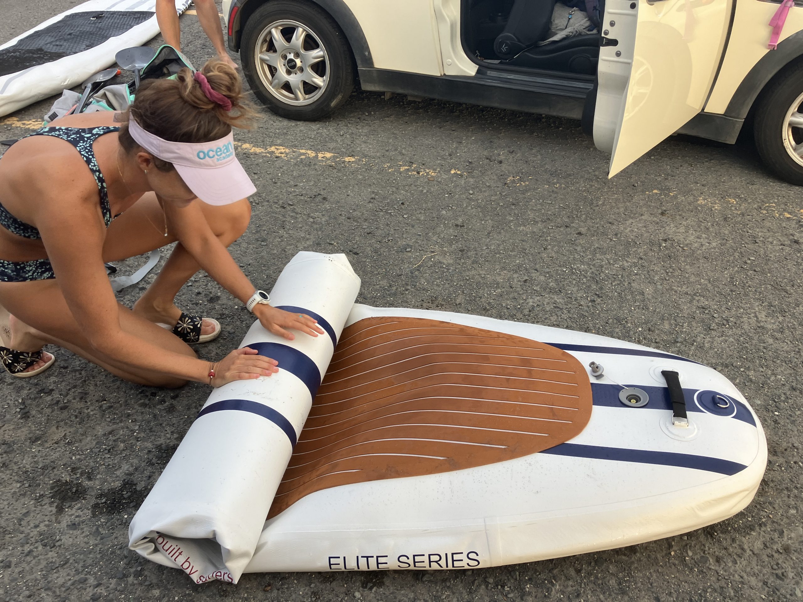 woman rolling up an inflatable stand up paddle board