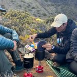 three friends making meals using backpacking stoves