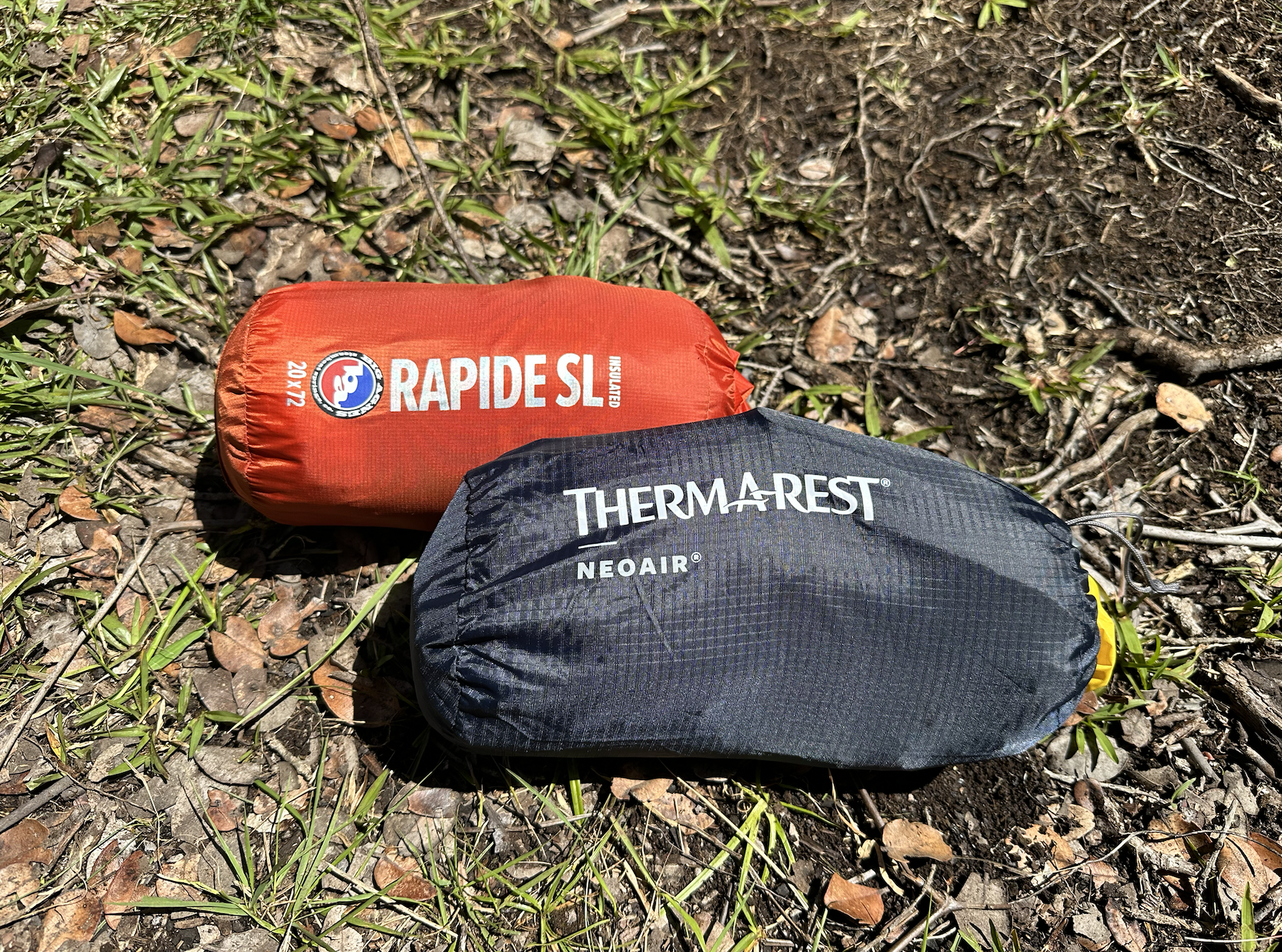 two backpacking sleeping pads packed up