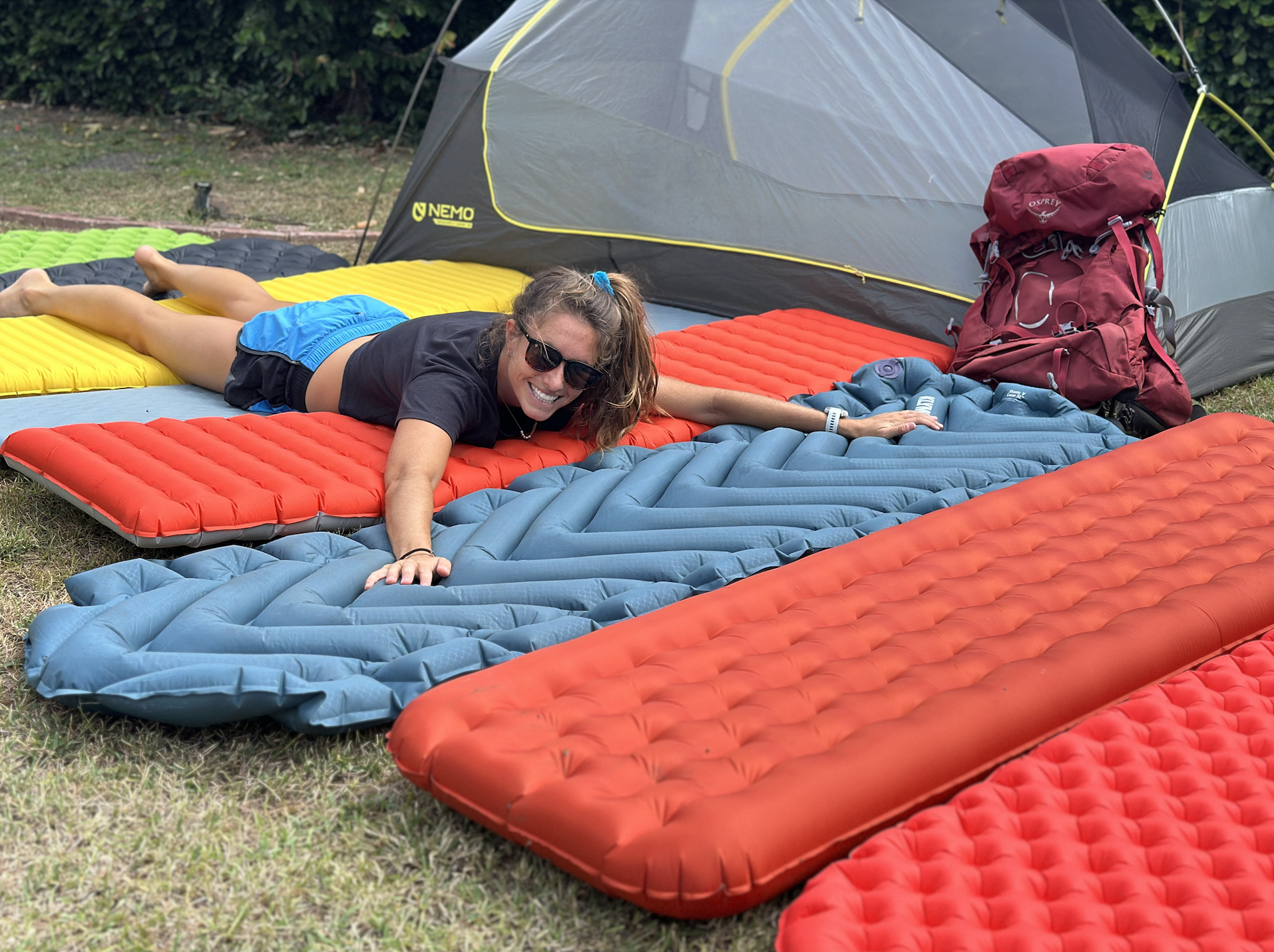 a woman laying on top of backpacking sleeping pads