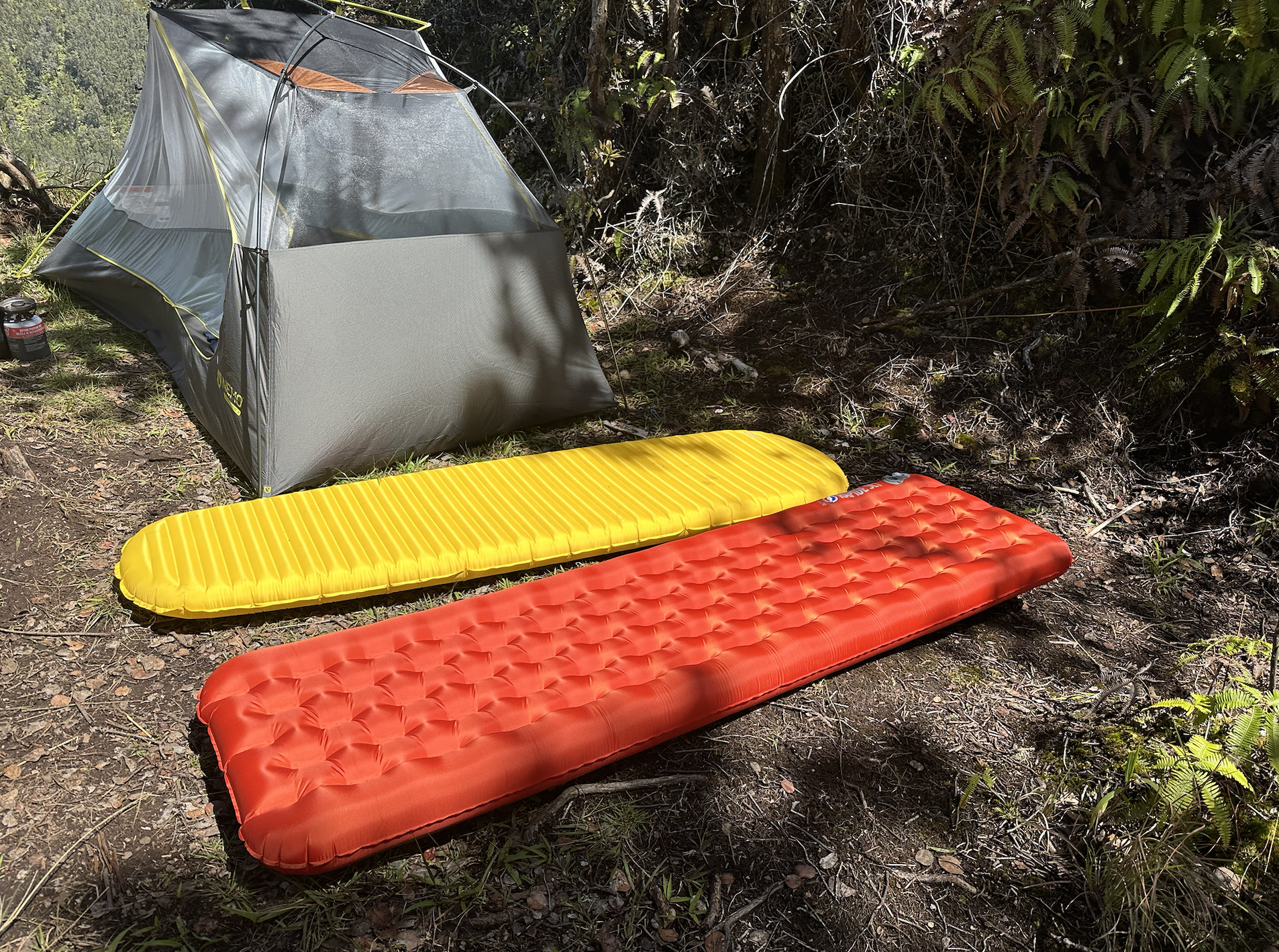 two backpacking sleeping pads on the ground