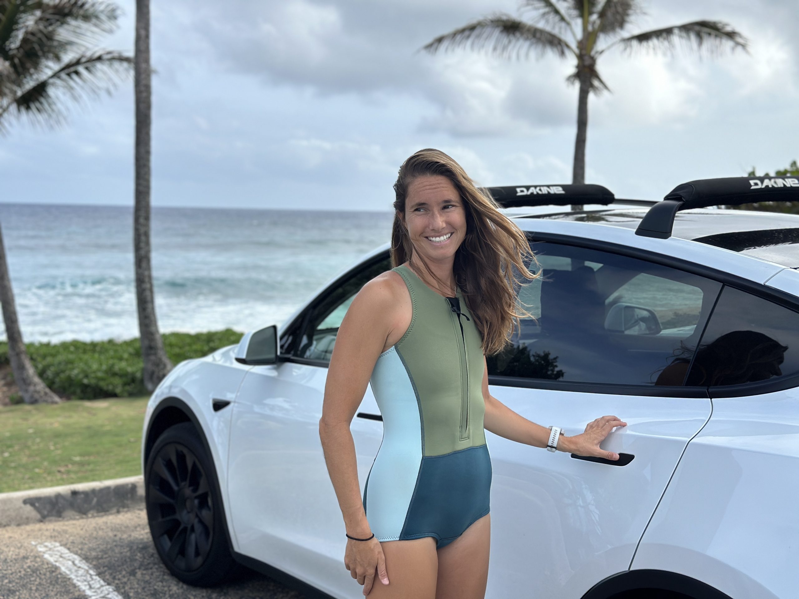 a woman in a springsuit next to a car