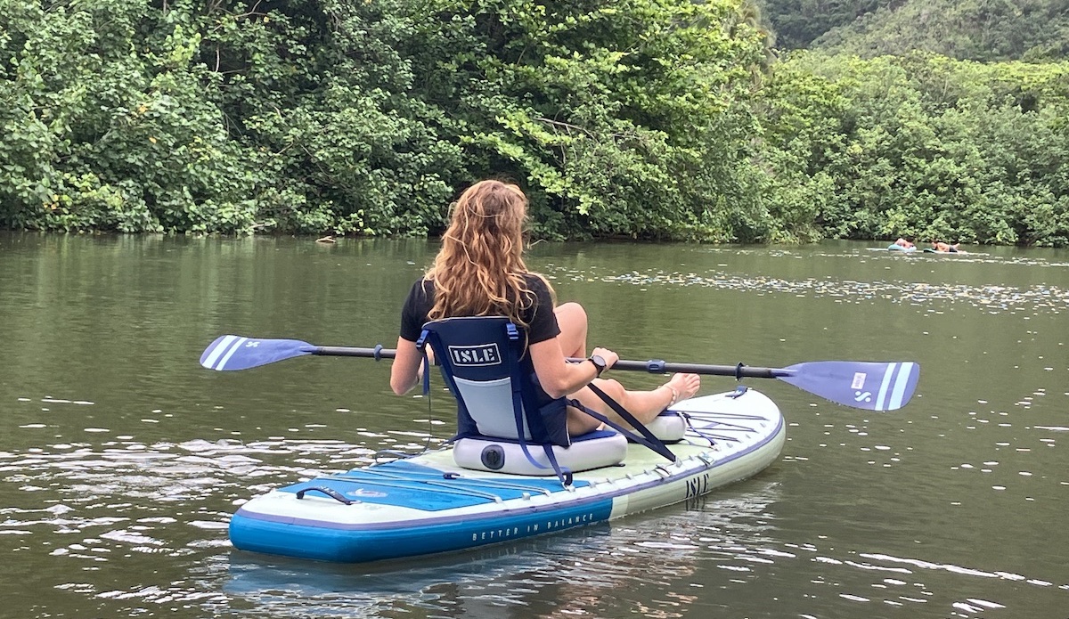 a woman kayaking in a lagoon on an ISLE board