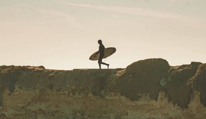 Man Walking with Surfboard on Cliff Steamer Lane