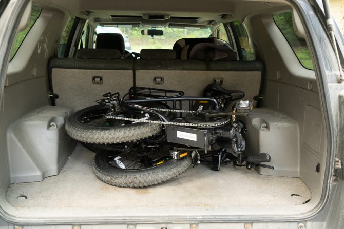 the engwe l20 2.0 electric bike folded up in the back of a toyota 4runner