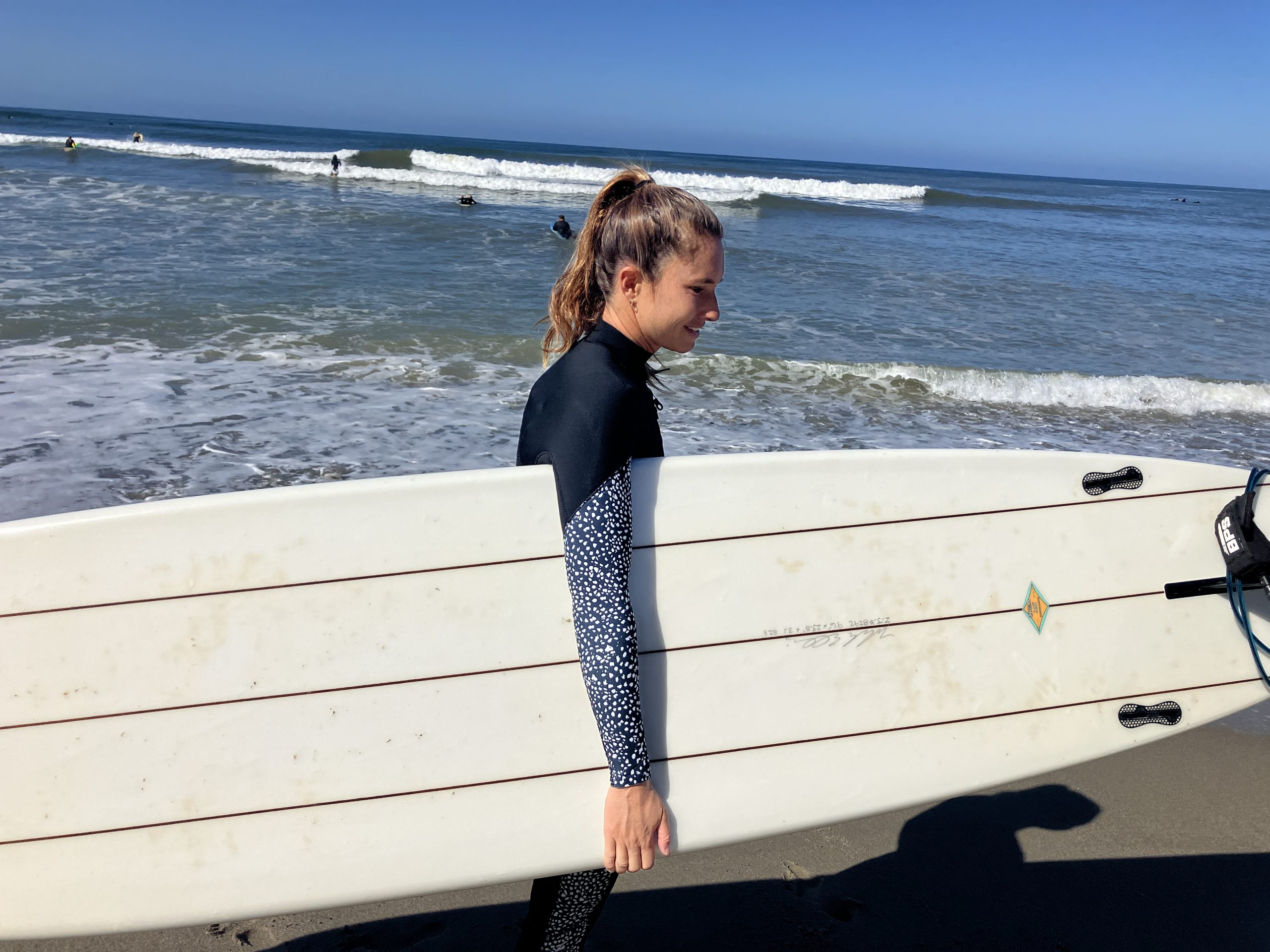 a woman holding a surfboard at the beach