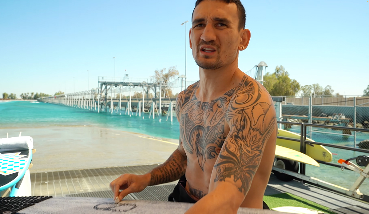 Max Holloway waxes up before riding Kelly's wave. Photo: Max Holloway // YouTube