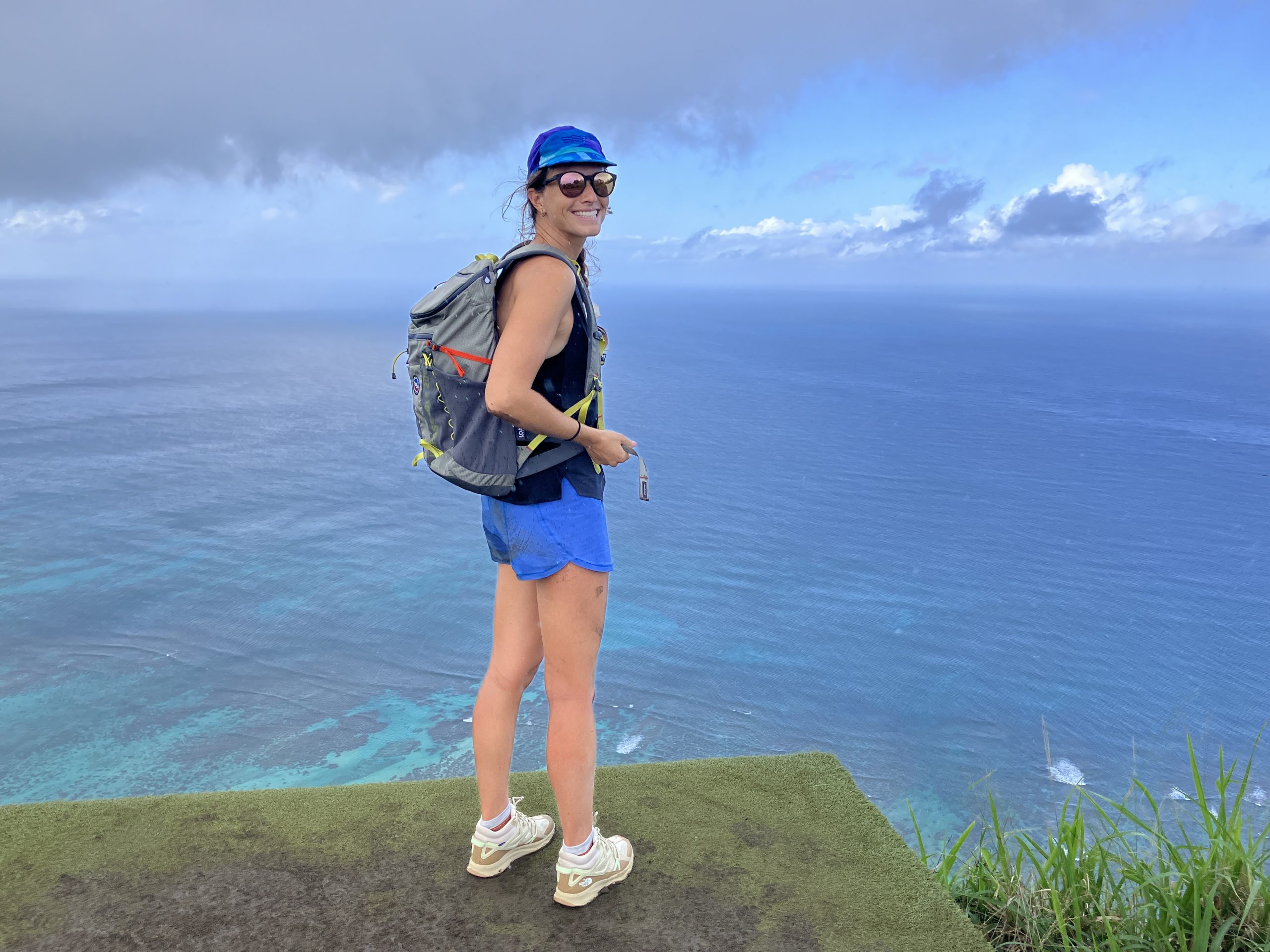 a woman hiking wearing hiking backpacks with an ocean view