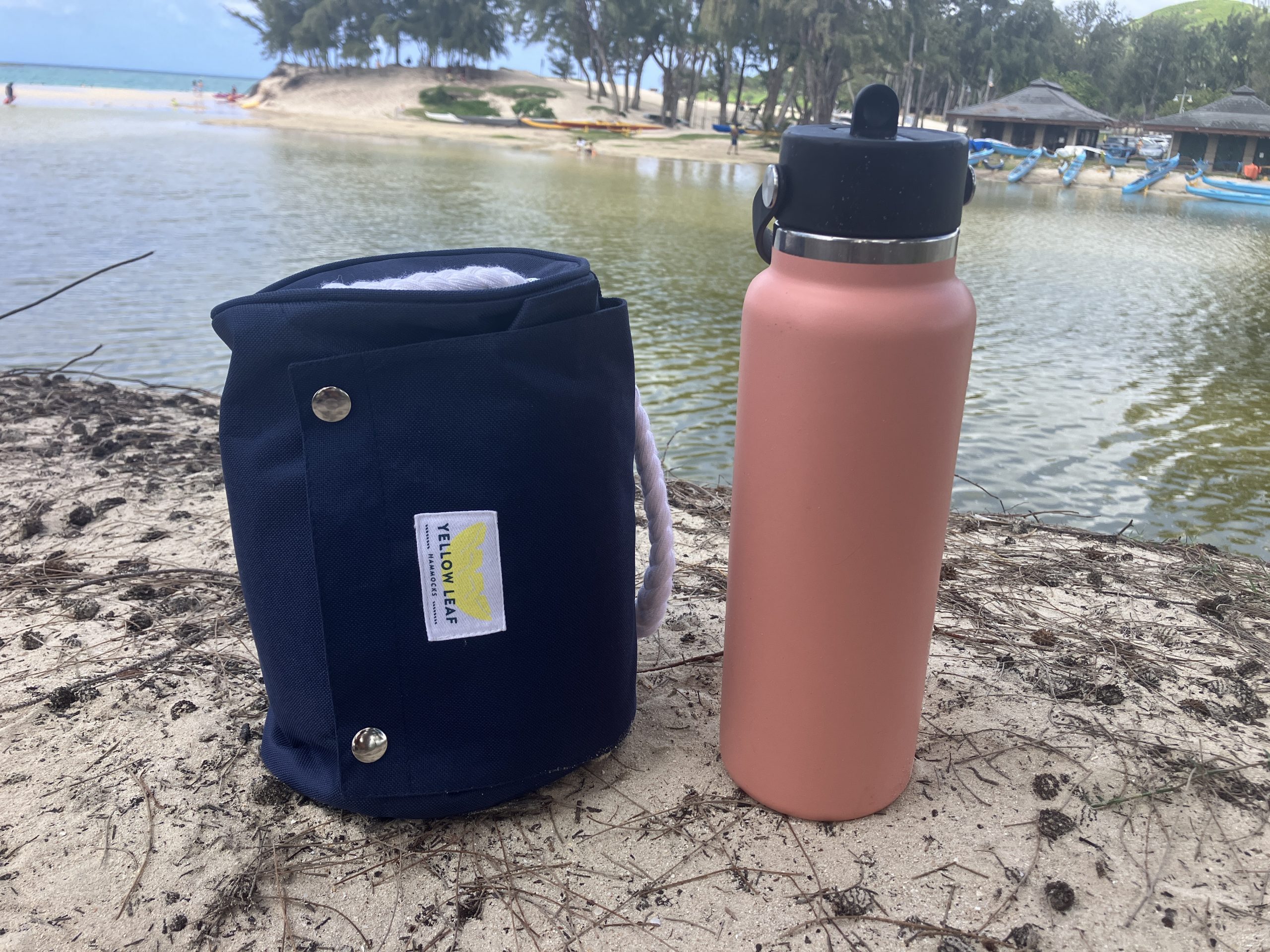 a packed up hammock next to a water bottle 